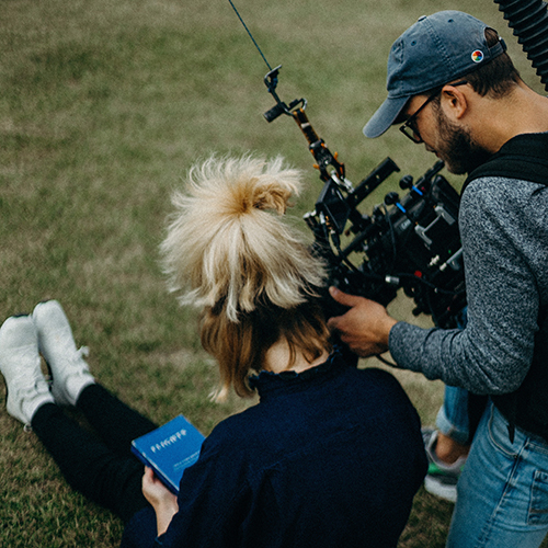 A director with a camera guides a participant through a scene.